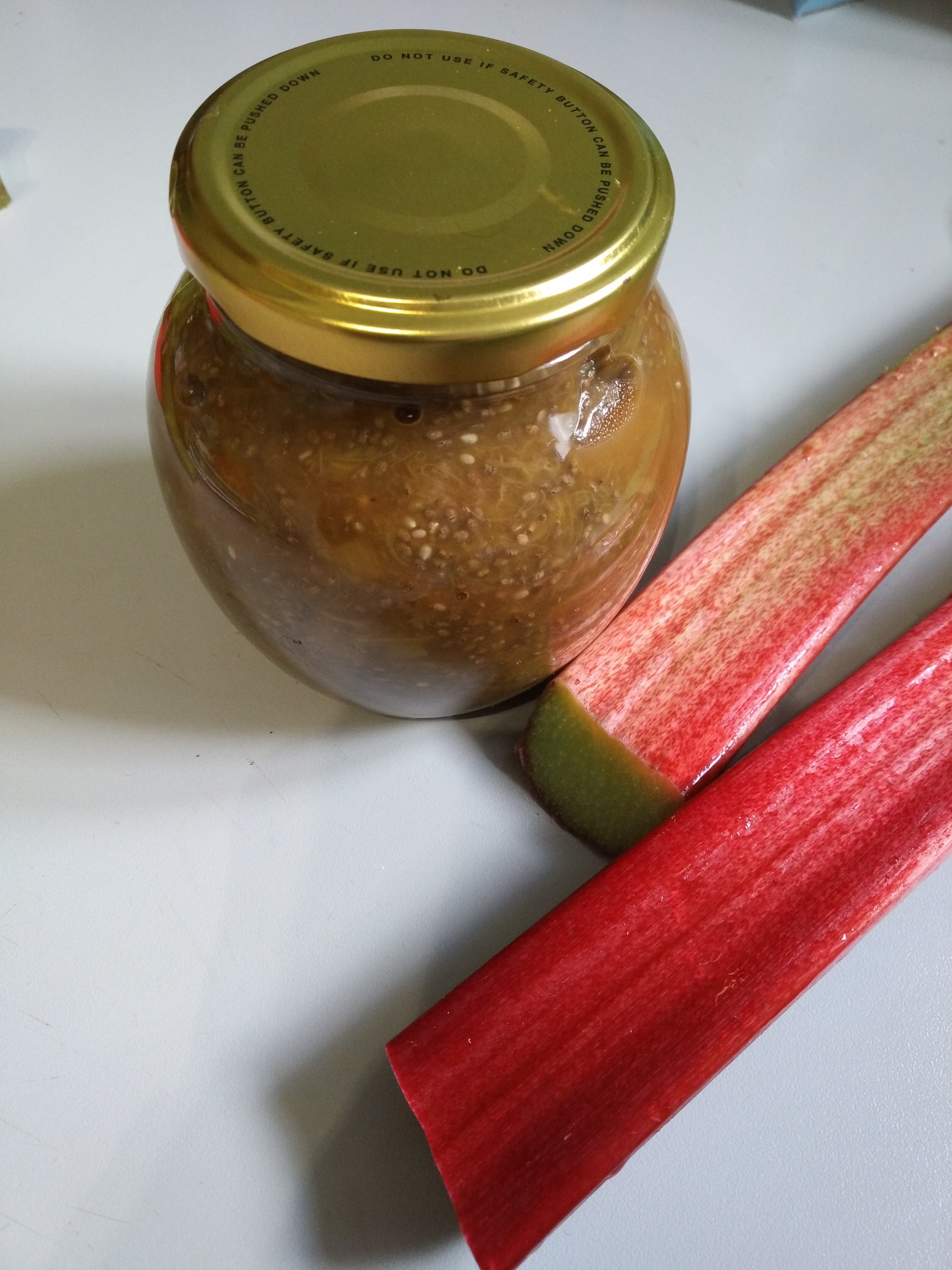 Rhubarb & ginger chia jam recipe by Kirstie Anne Wellbeing - jar of jam on kitchen worktop with two stalks of fresh rhubarb