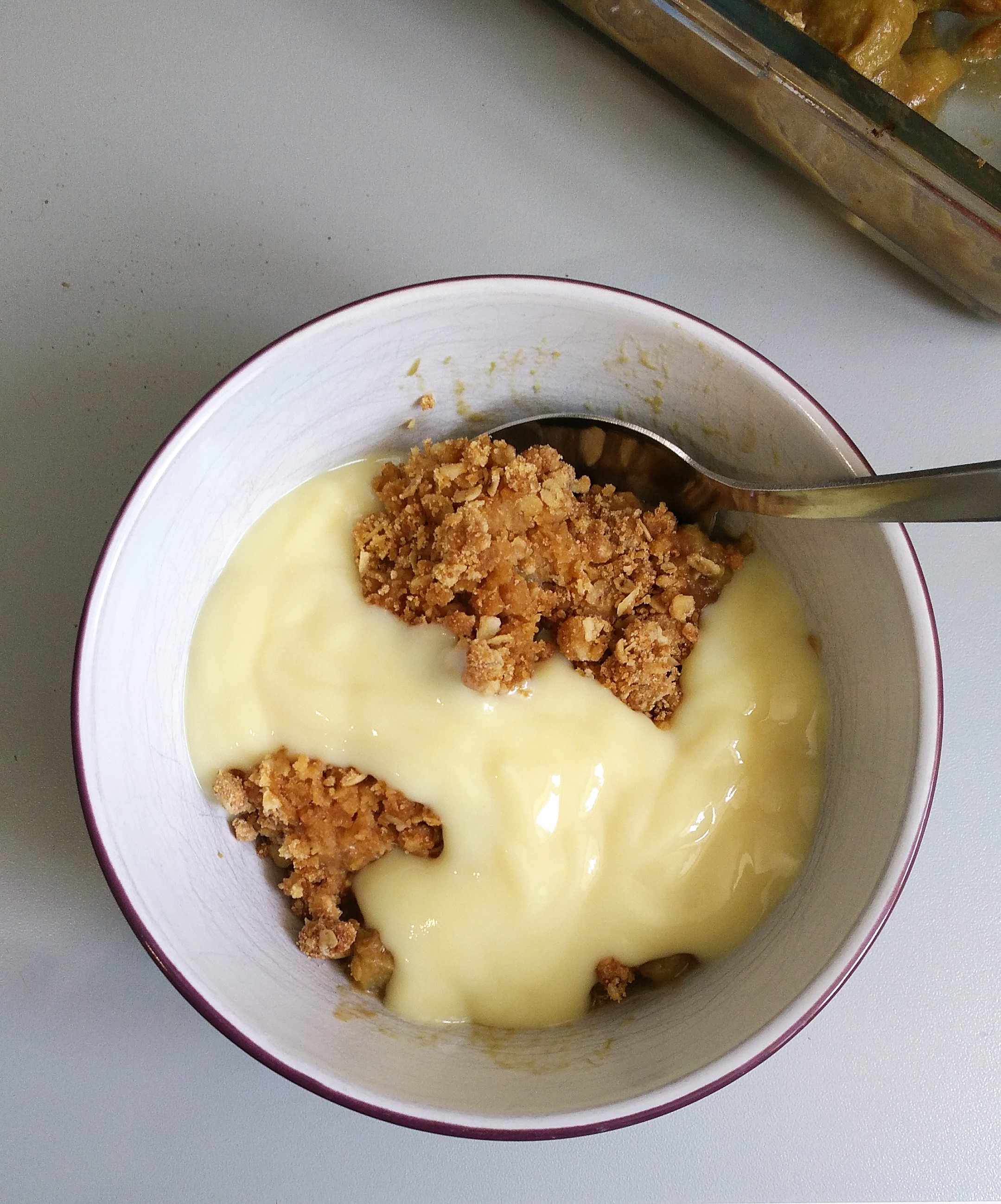Gluten Free Rhubarb and Ginger crumble recipe with dairy free custard in a bowl