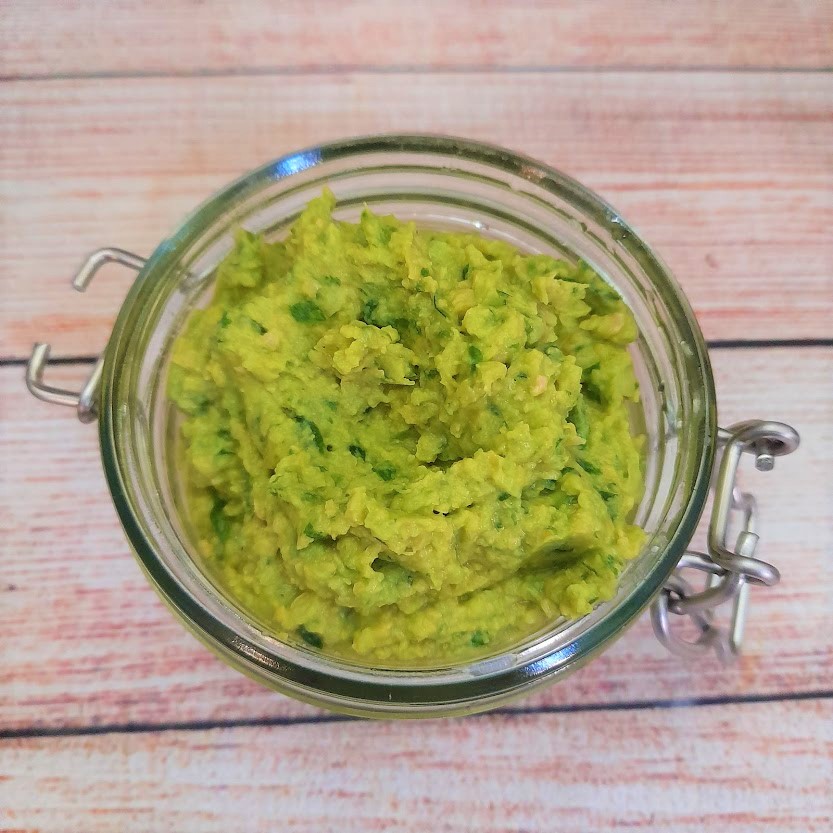 vegan wild garlic hummus in a glass jar on a table. recipe by kirstie anne wellbeing